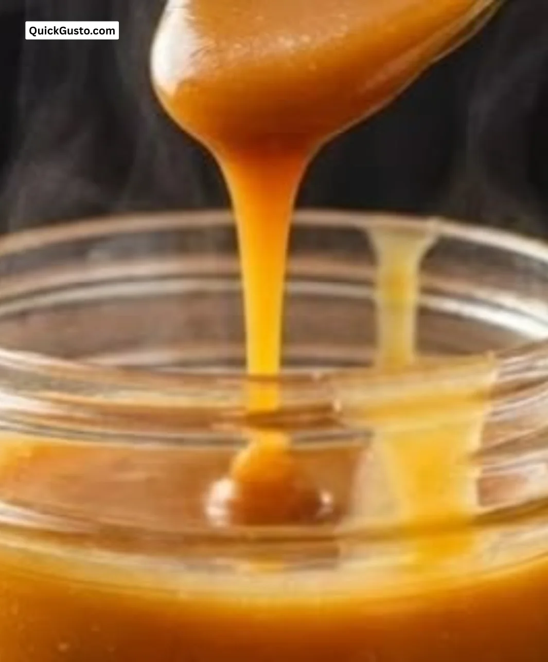 Homemade easy butterscotch sauce in a glass jar with a spoon.