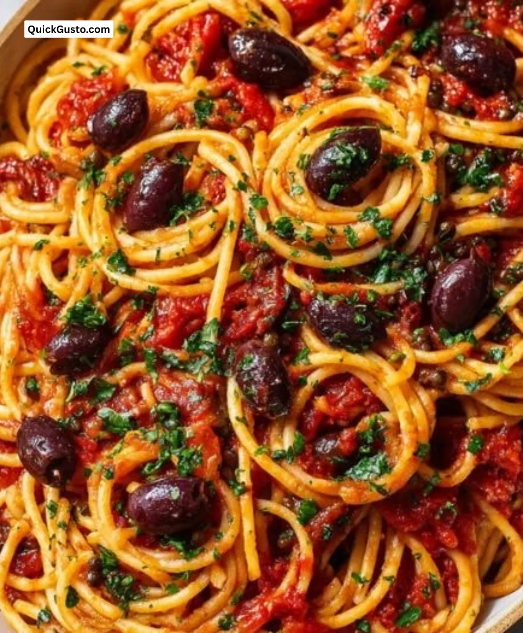 Delicious Pasta Puttanesca garnished with olives and capers on a plate