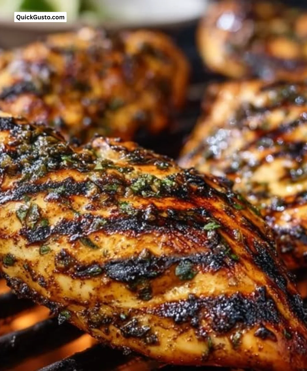 Juicy grilled chicken on a plate seasoned with herbs and spices.