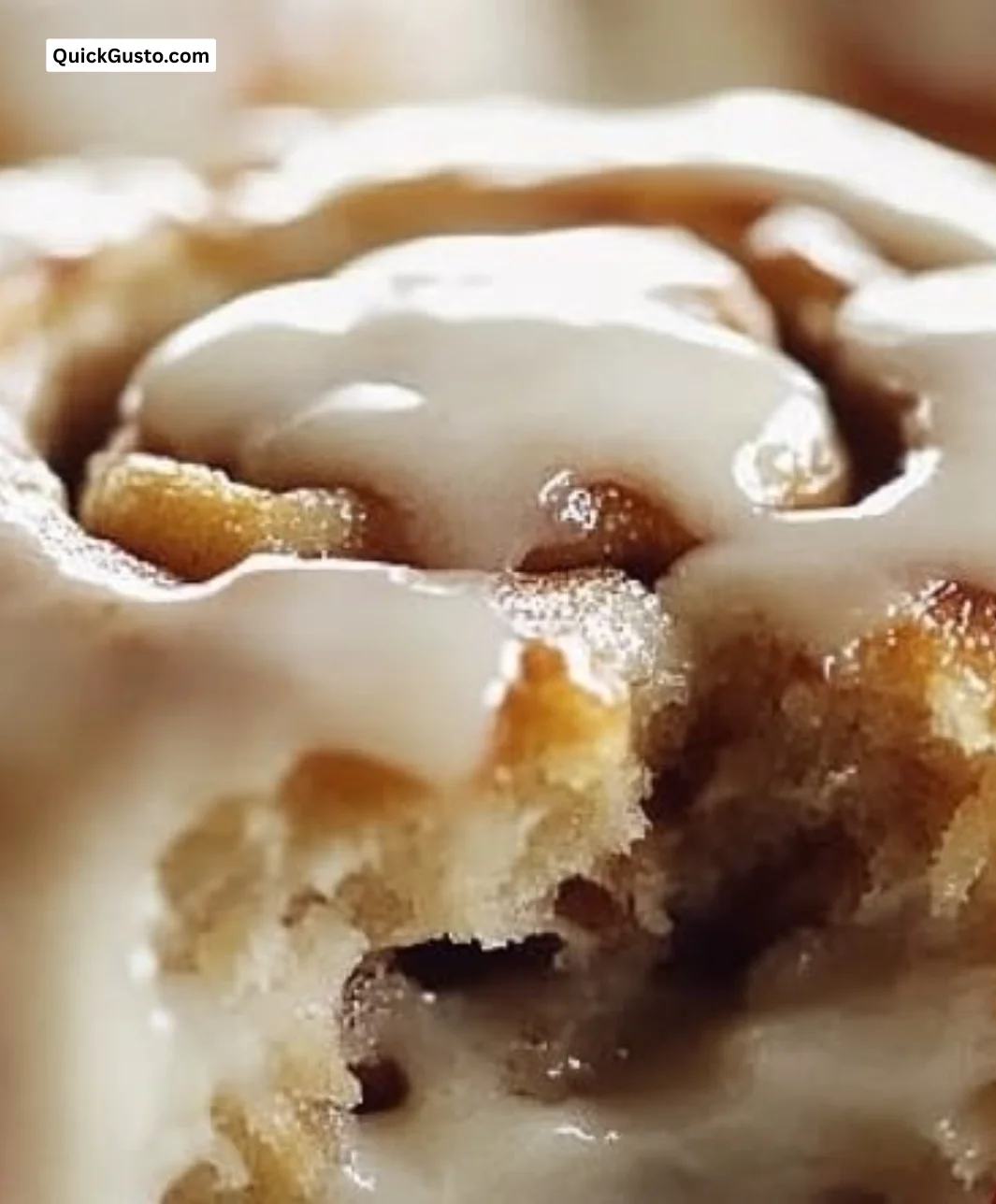 Freshly baked Amish cinnamon rolls drizzled with icing on a wooden table