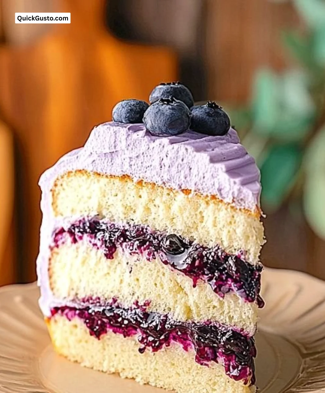 Delicious slice of blueberry chiffon cake topped with fresh blueberries
