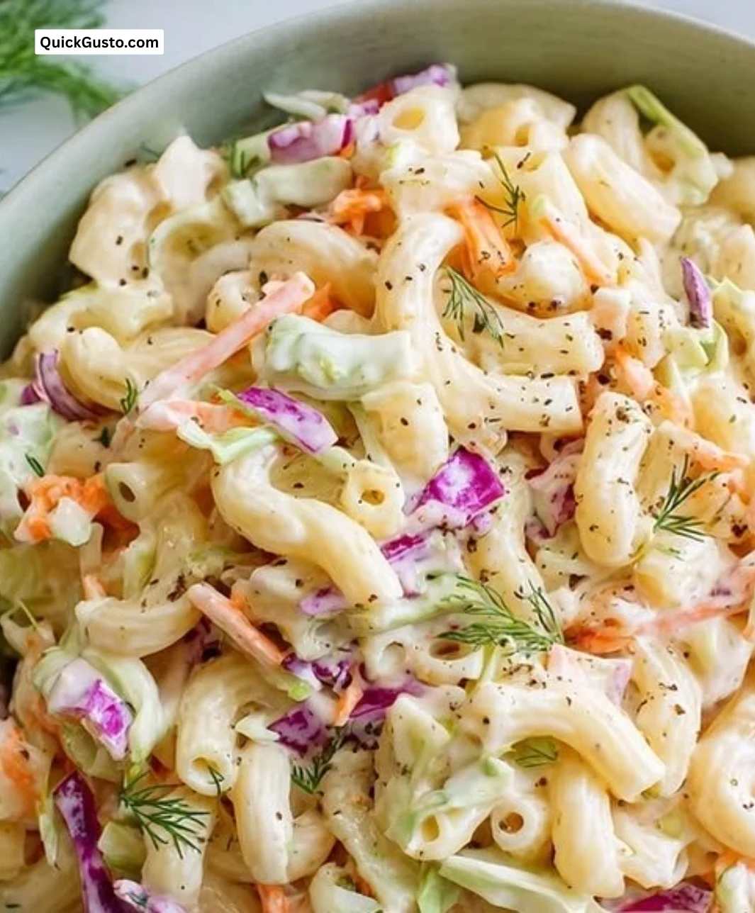 Colorful pasta salad with coleslaw dressing and fresh vegetables in a bowl