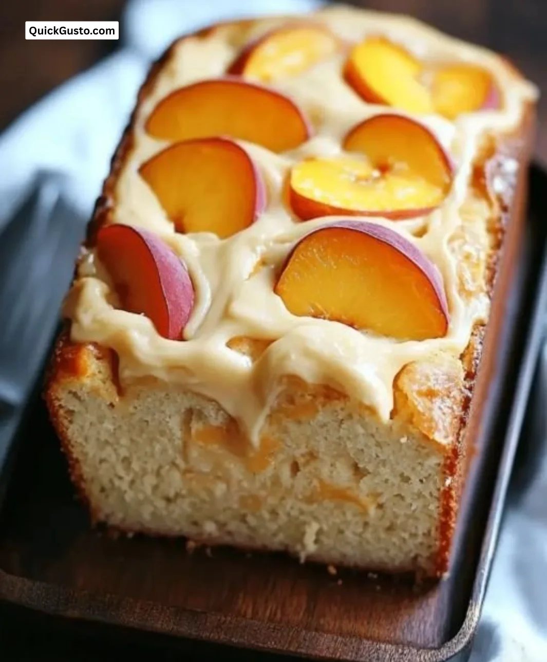 Moist peach cream cheese loaf with fresh peaches and cream cheese glaze on top