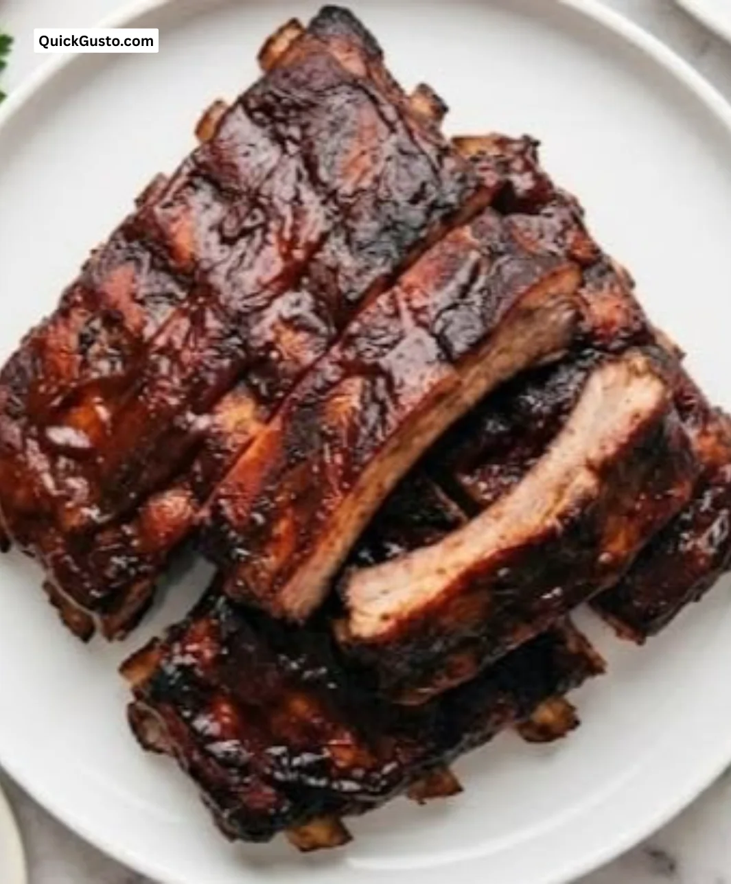 Delicious oven glazed ribs coated in a sticky sweet sauce ready for serving.