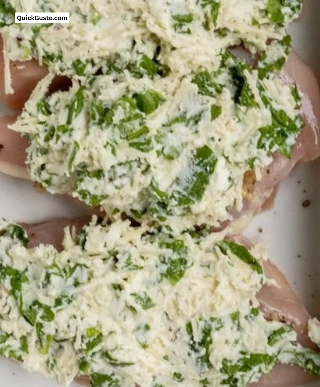 Baked spinach ricotta chicken garnished with herbs and served on a plate