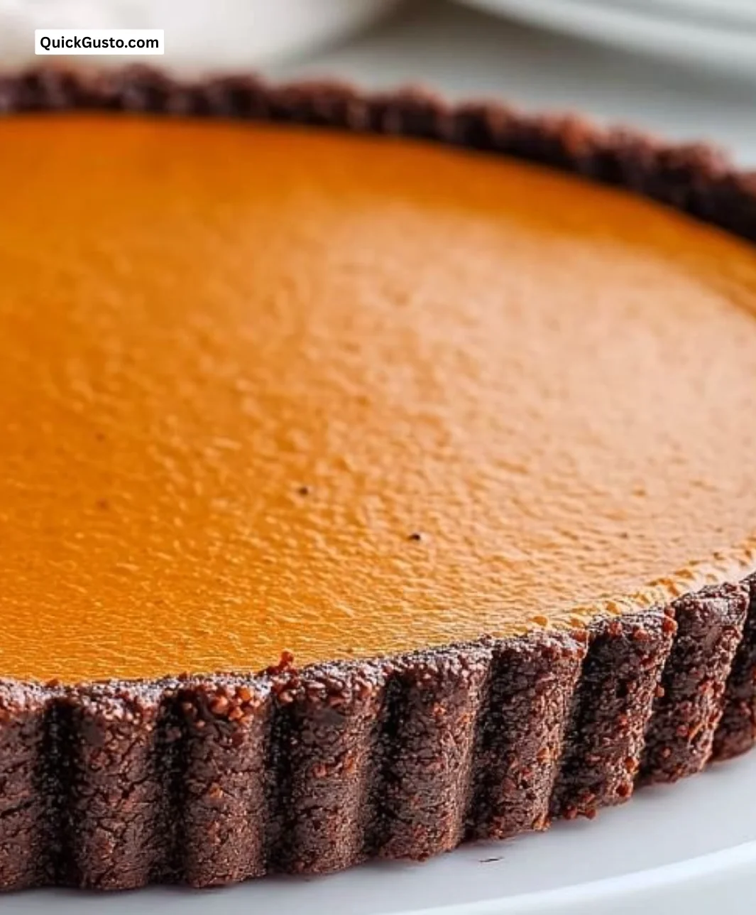 Simple dark chocolate pumpkin tart served on a plate with a fork