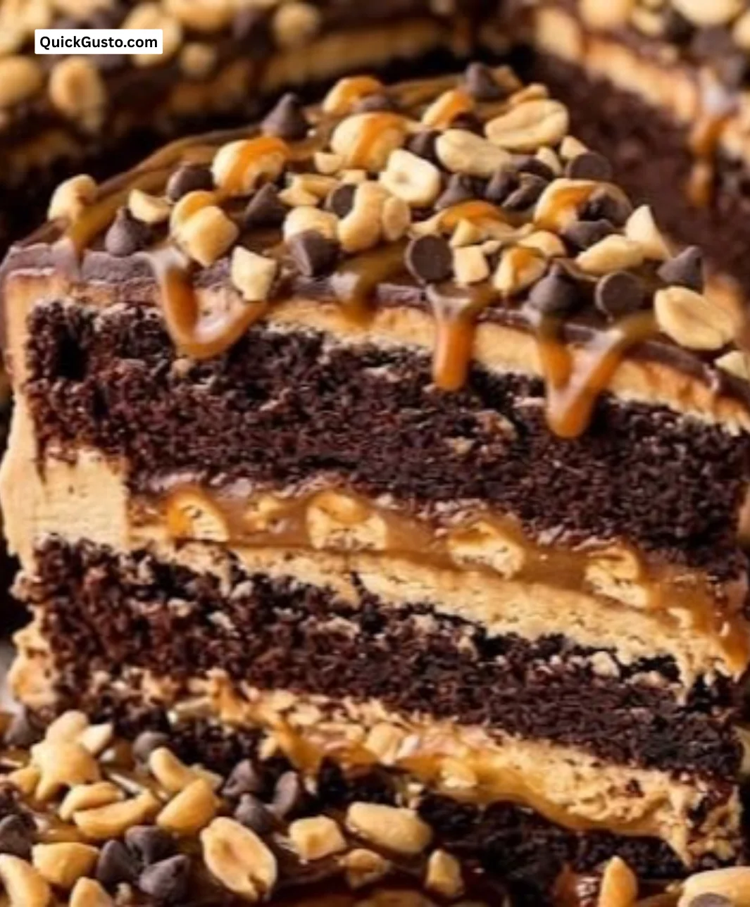 A slice of Snickers Cake topped with caramel and peanuts on a dessert plate.