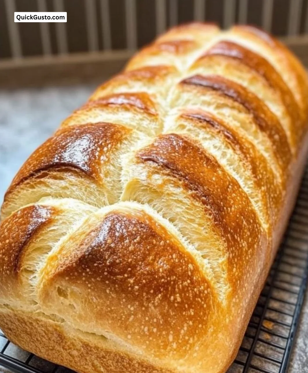 Soft and fluffy sourdough sandwich bread loaf on a rustic wooden table.