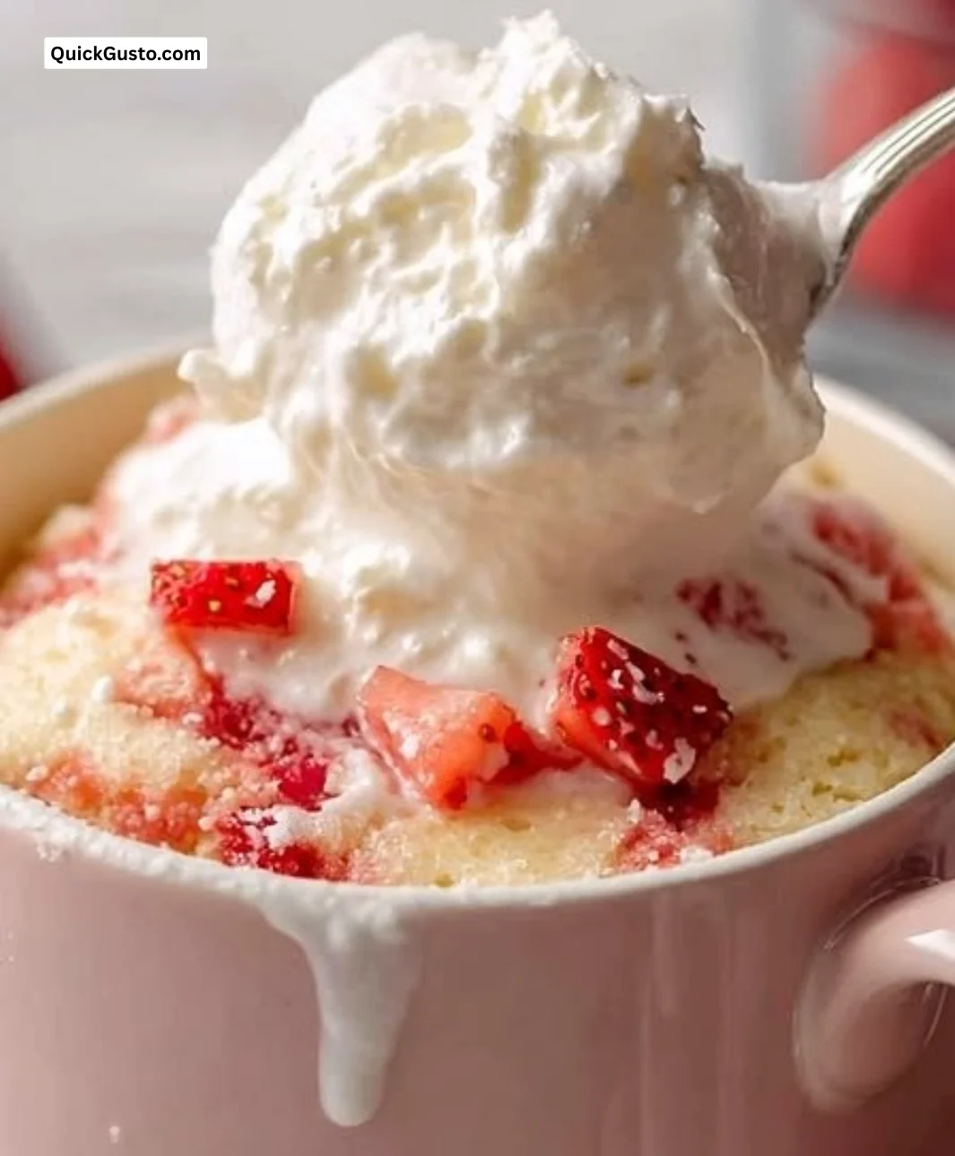 Soft strawberry mug cake in a cozy mug, topped with fresh berries.