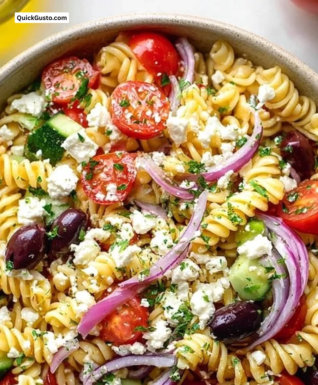 Colorful Greek Pasta Salad with feta cheese, olives, and herbs in a bowl