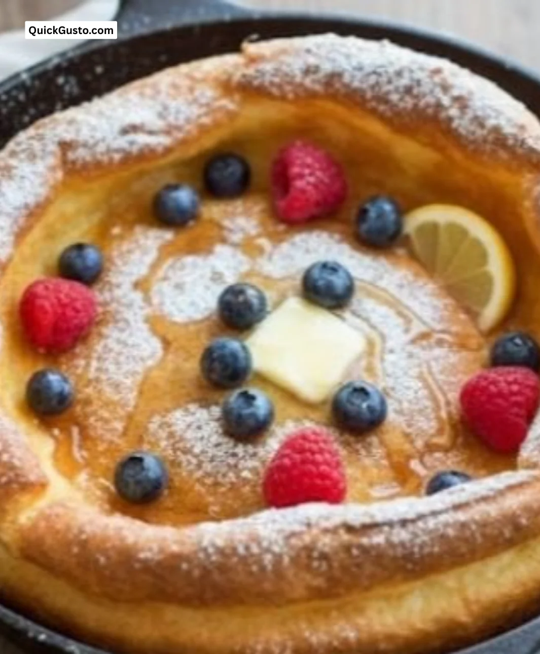 Fluffy Sunrise Dutch Baby pancake topped with fresh fruits and syrup