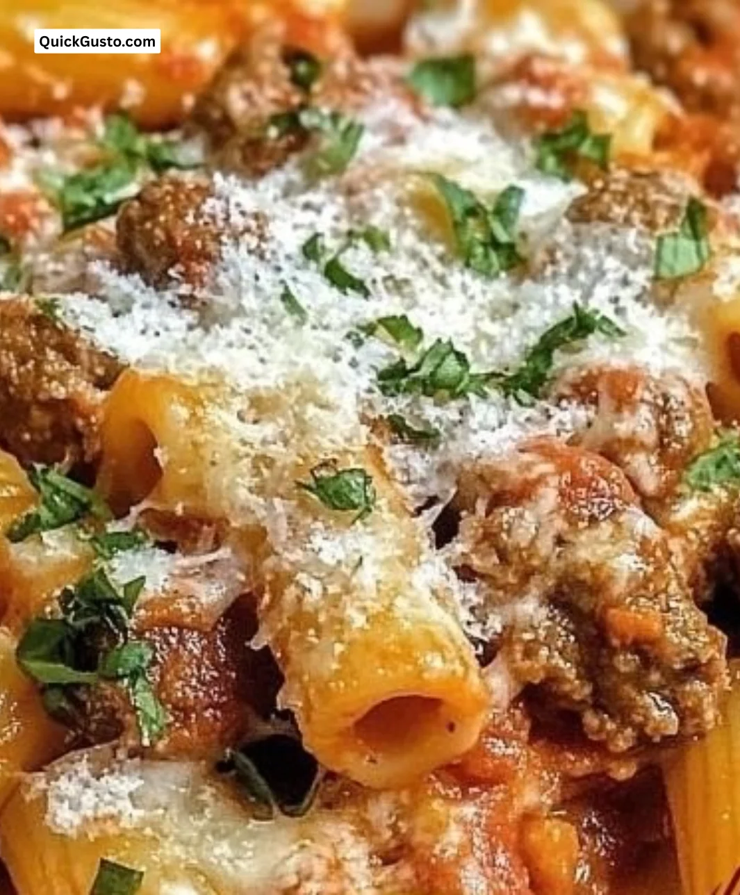 Cheesy Italian sausage rigatoni served in a bowl with herbs