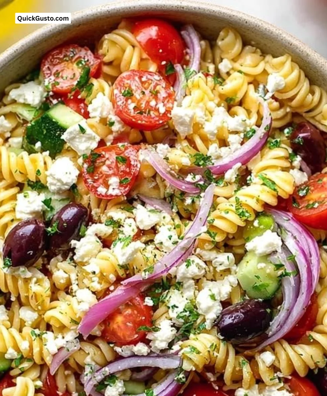 Colorful traditional Greek pasta salad with herbs, olives, and vegetables