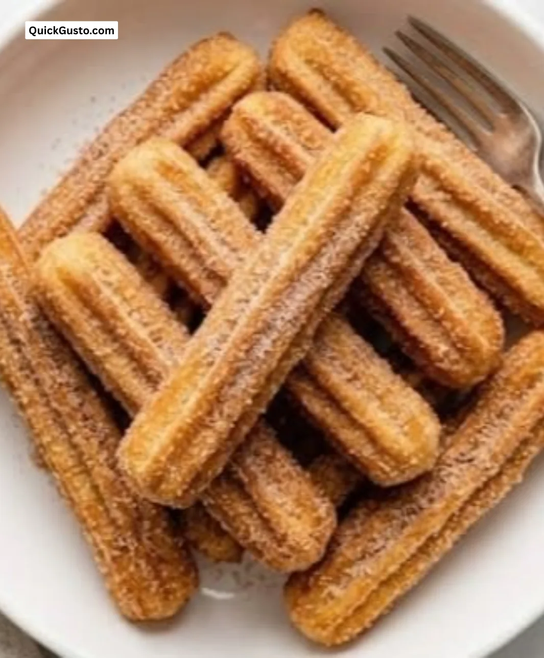 Freshly made golden-brown churros ready to be enjoyed with chocolate sauce.