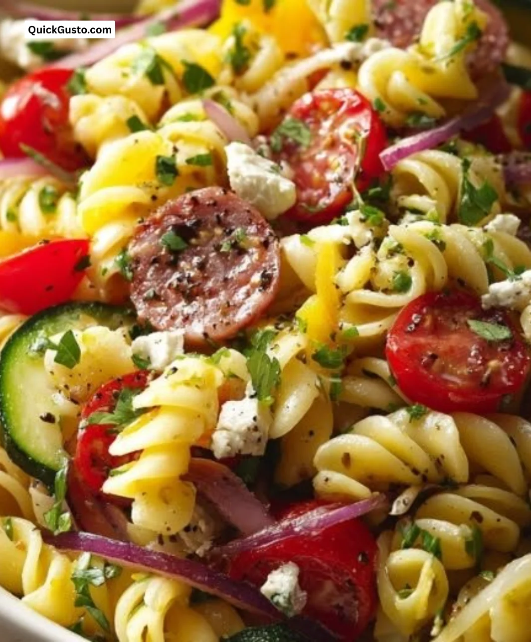A colorful bowl of zesty Italian Pasta Salad with fresh vegetables and herbs.