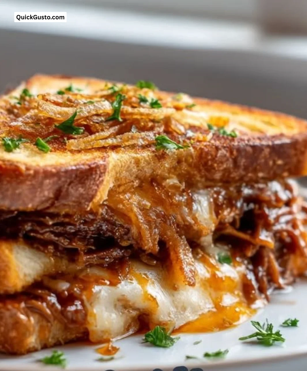 Delicious BBQ brisket melts served on a plate, topped with melted cheese.