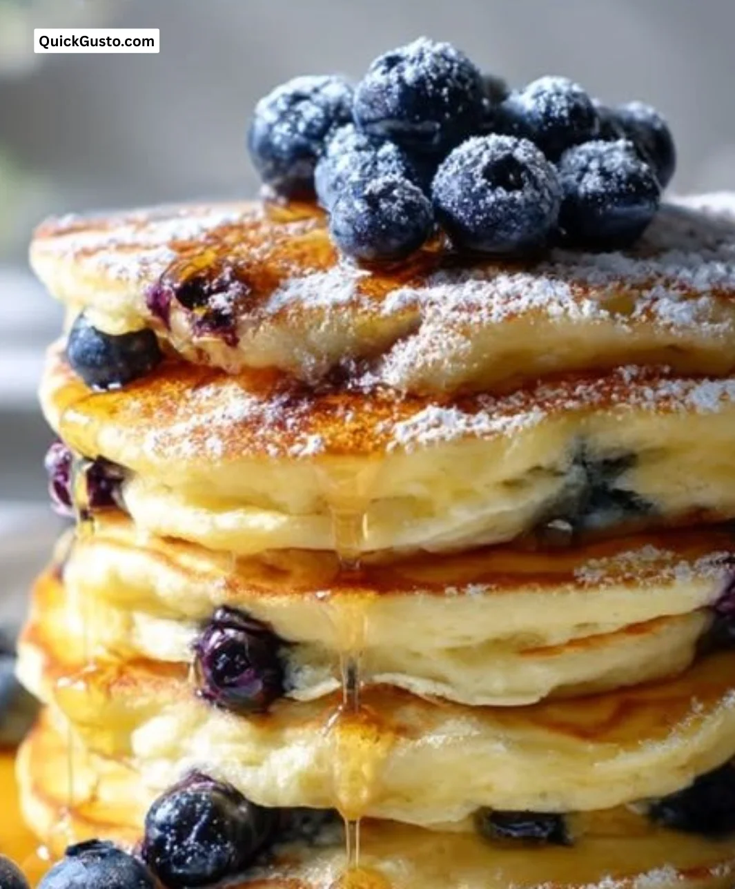 Fluffy blueberry buttermilk pancakes stacked with fresh blueberries and syrup