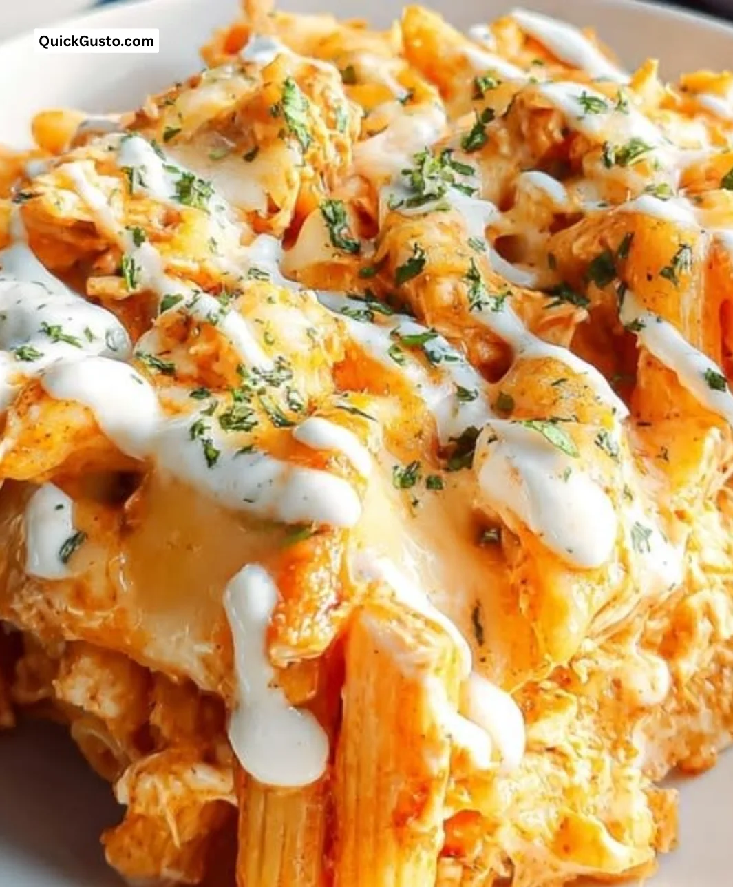 Plate of creamy Buffalo Chicken Pasta topped with green onions and cheese