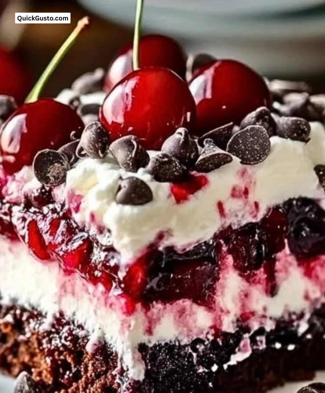Delicious Cherry Chocolate Chip Poke Cake served on a plate with a cherry garnish.