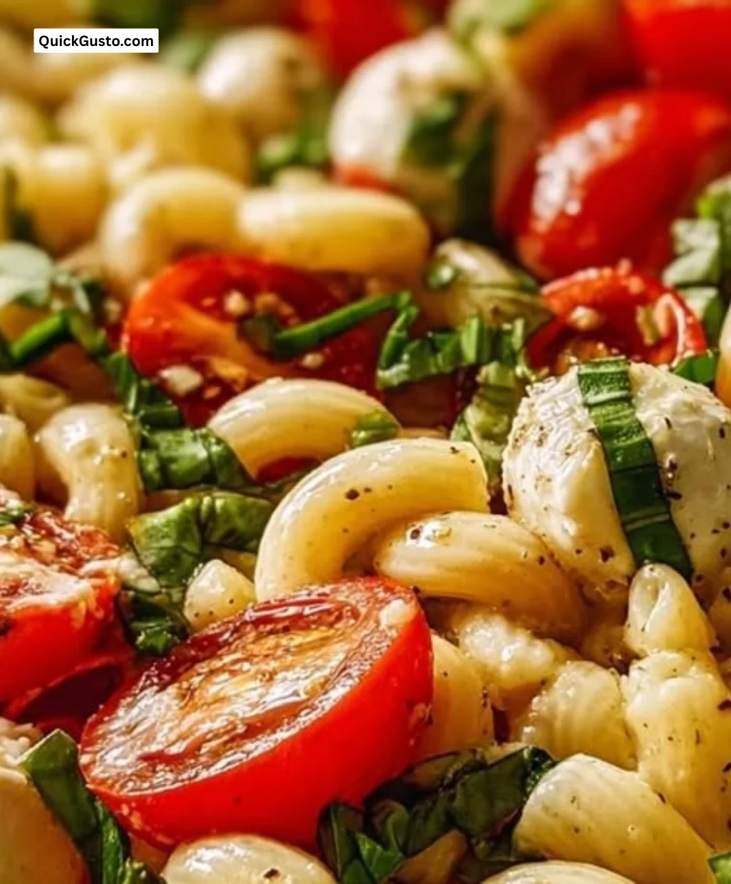 Creamy Caprese Pasta Salad with tomatoes, basil, and mozzarella in a bowl