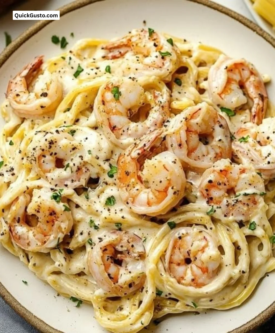 Creamy garlic shrimp pasta served in a bowl with herbs and parmesan cheese.