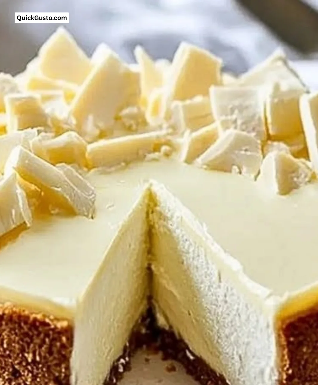 Creamy white chocolate cheesecake slice topped with chocolate shavings