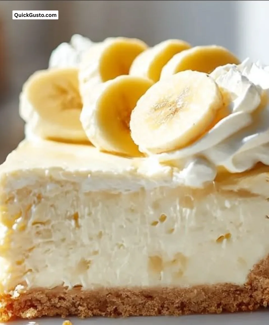 Slice of banana cream cheesecake topped with whipped cream and banana slices