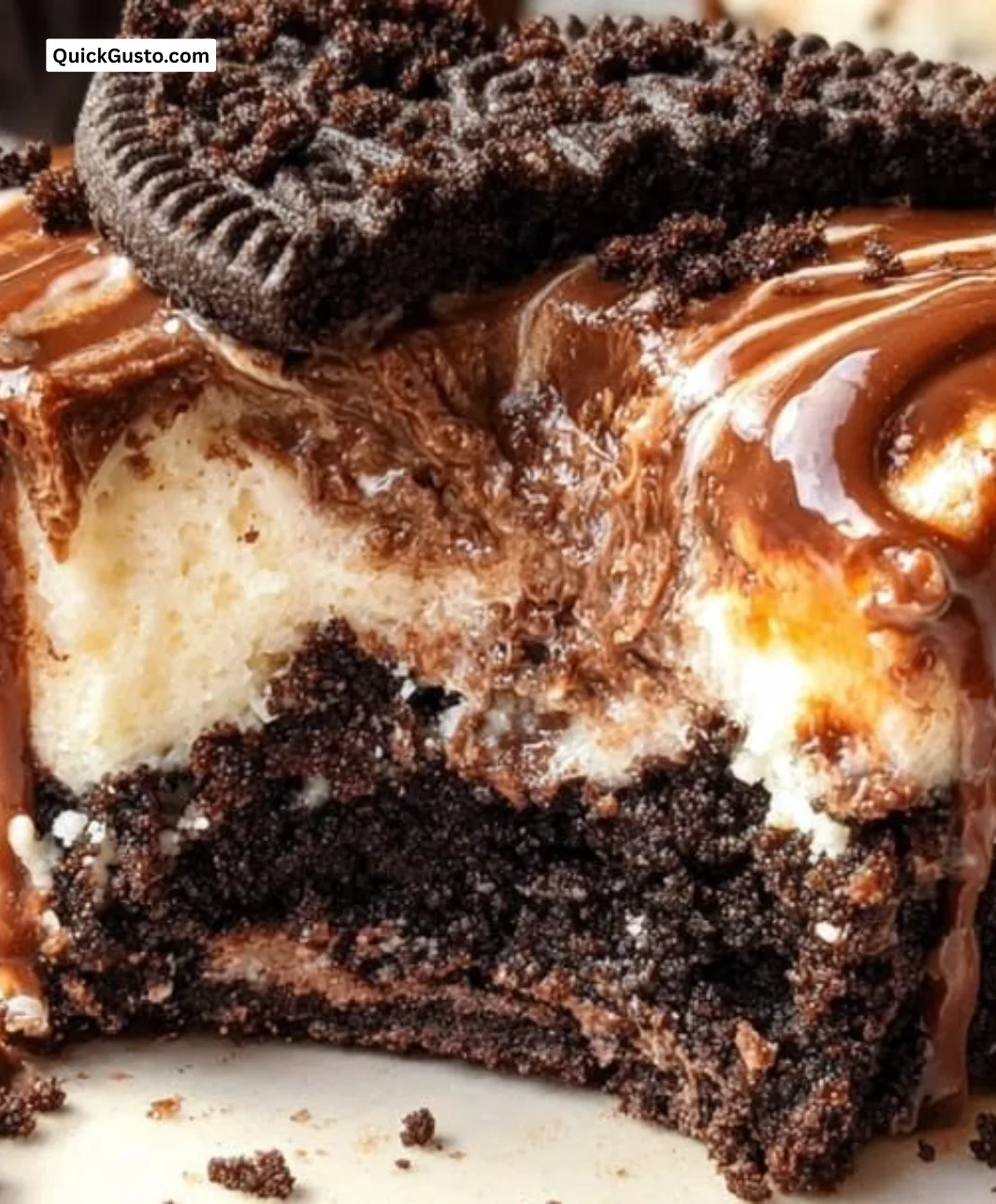 Fudge swirled Oreo bottom cheesecake cupcakes topped with chocolate drizzle