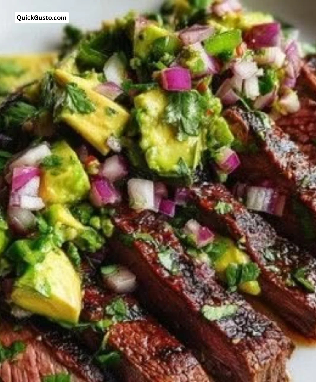 Grilled flank steak served with fresh avocado salsa on a plate.