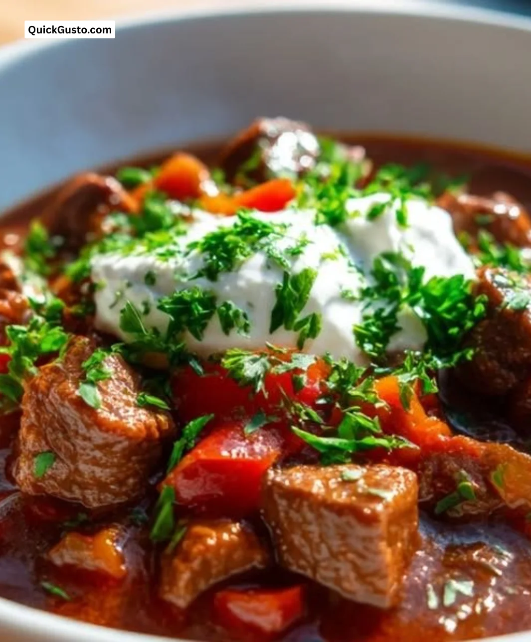 Delicious bowl of rich and savory beef goulash served with fresh herbs