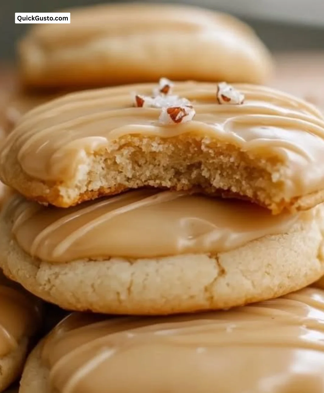 Soft maple cookies with brown butter icing on a rustic wooden table.