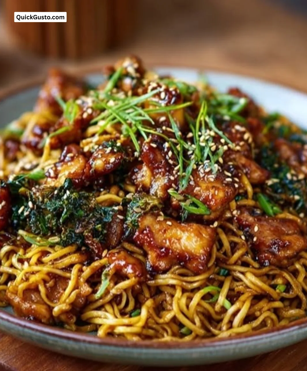 Bowl of Sticky Garlic Chicken Noodles garnished with herbs and chopsticks