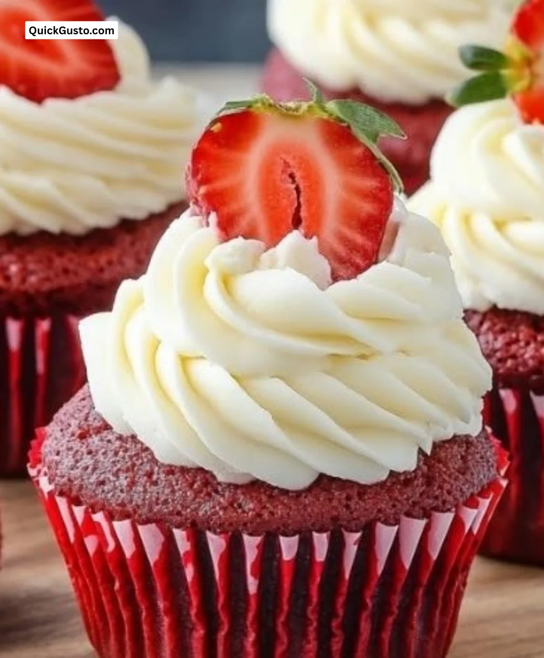 Delicious Strawberry Cheesecake Red Velvet Cupcakes topped with fresh strawberries.
