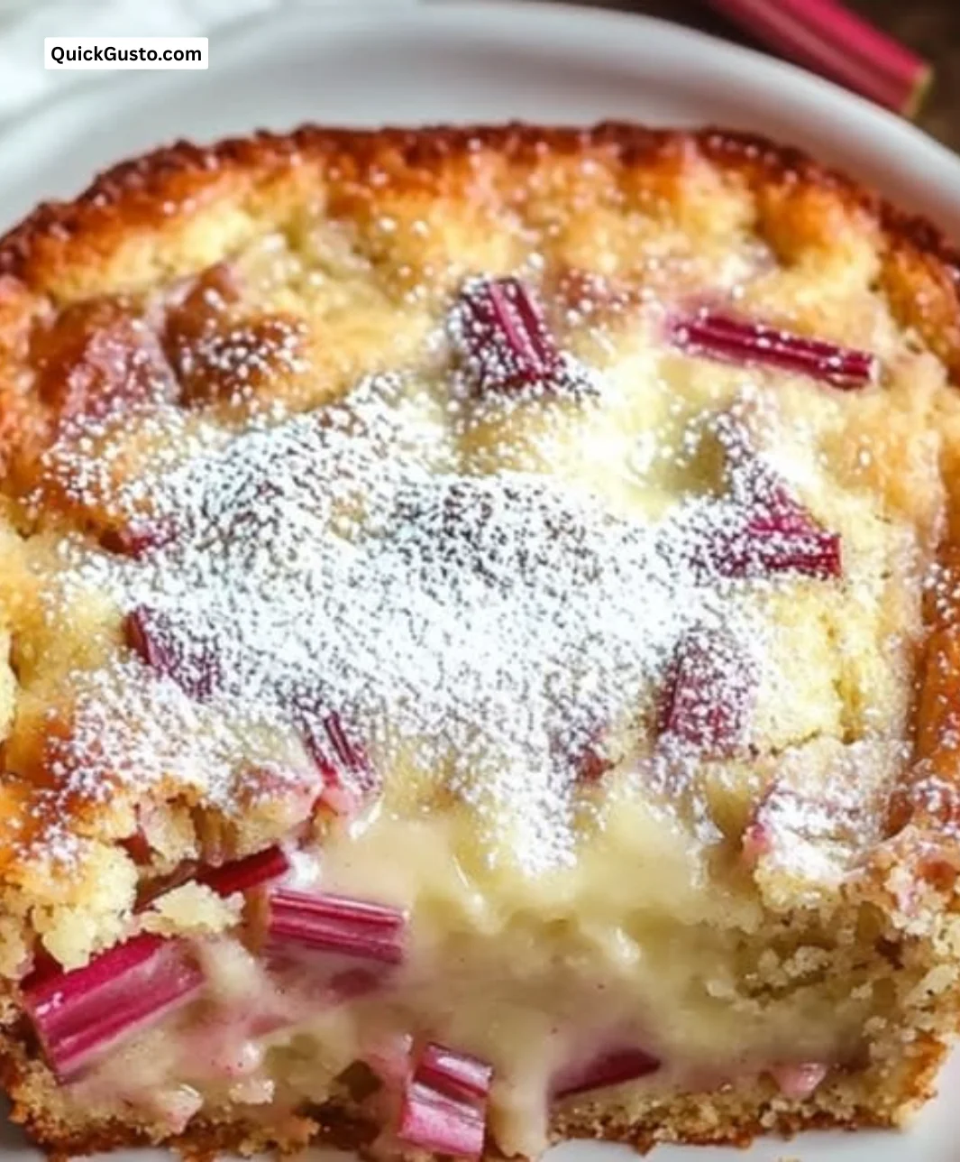 Warm rhubarb cake topped with creamy butter sauce on a plate