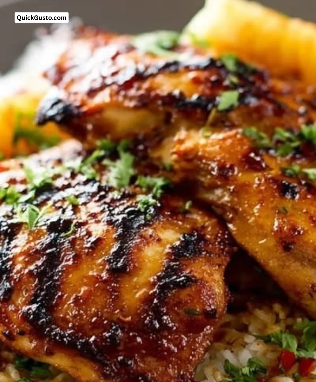 Hawaiian chicken served with coconut rice, garnished with tropical fruits and herbs.