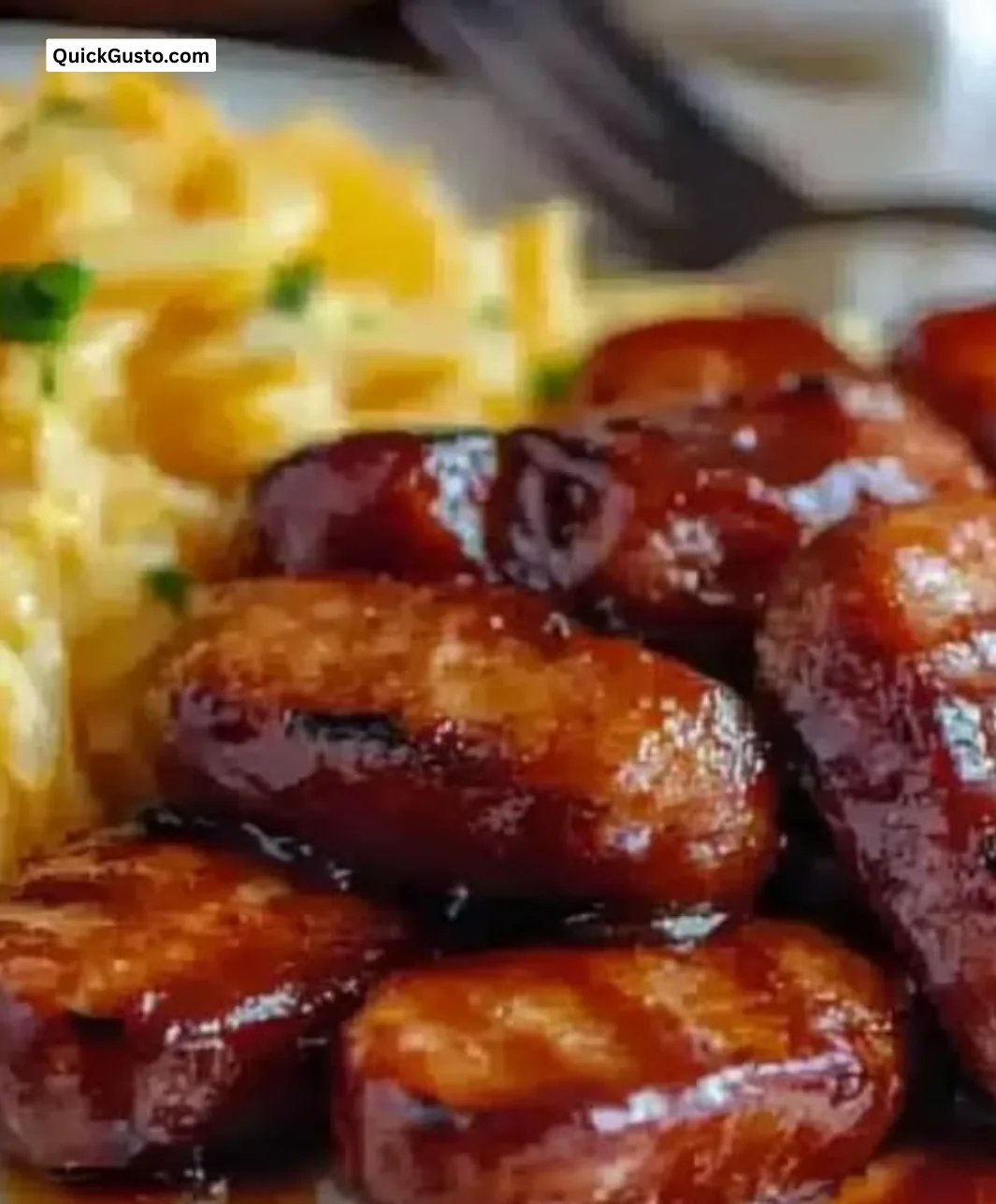 Baked BBQ sausage served on a plate with barbecue sauce and sides
