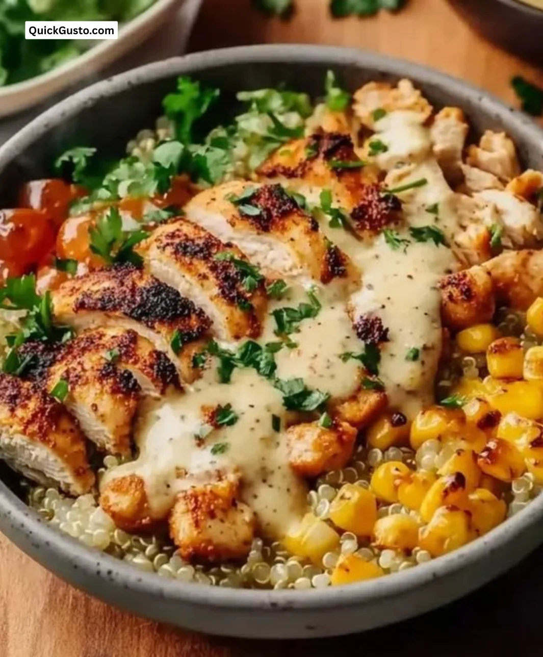 Delicious chicken quinoa dinner bowl topped with fresh vegetables and herbs