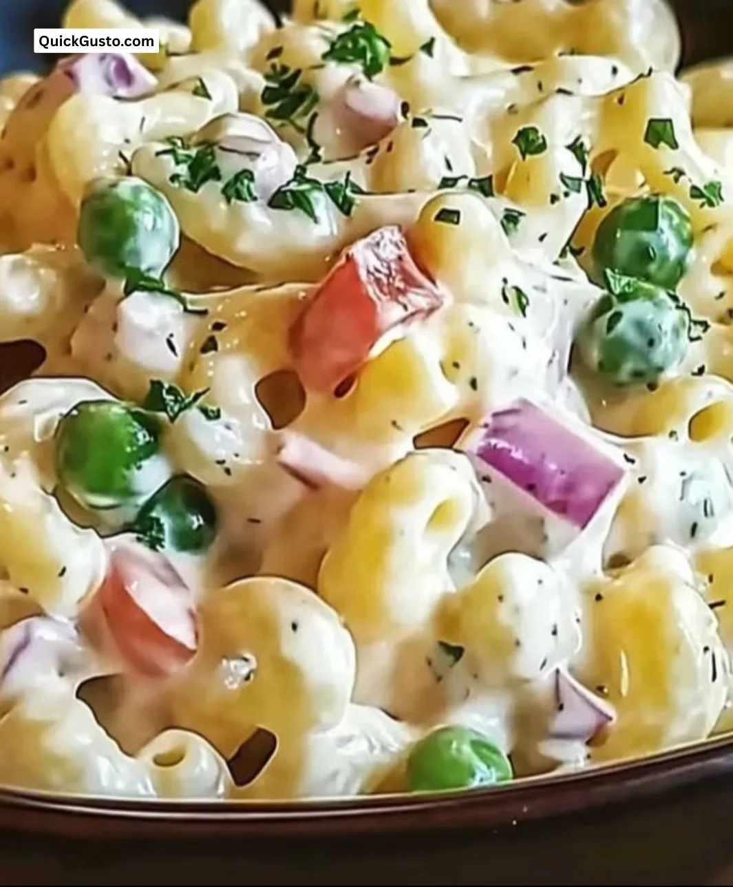 Delicious creamy macaroni salad served in a bowl, perfect for summer gatherings.