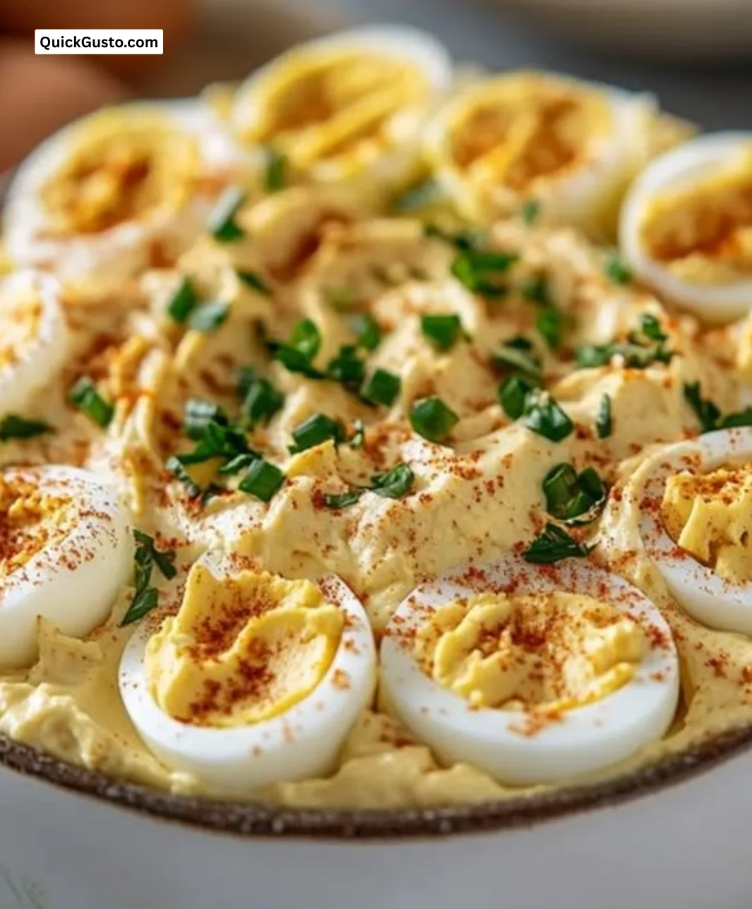 Bowl of creamy deviled egg dip served with vegetables and crackers