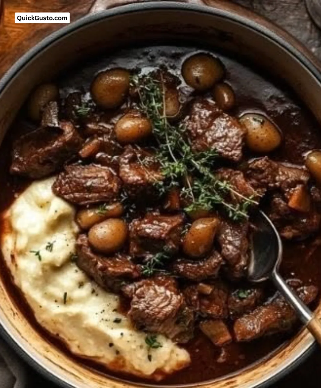 A bowl of easy French beef stew with creamy mashed potatoes on the side.
