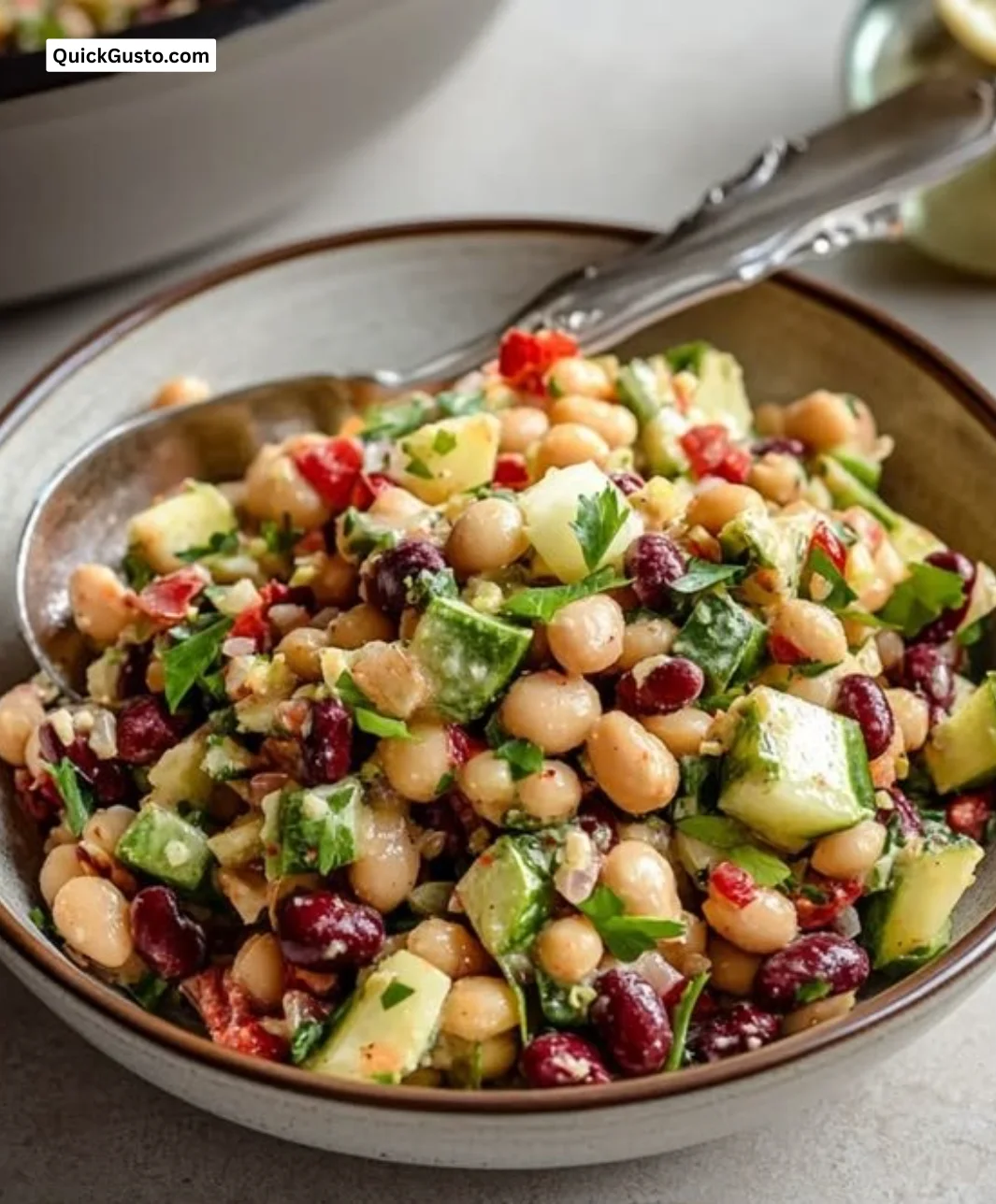 Bowl of Easy Mediterranean Three Bean Salad with fresh vegetables and herbs