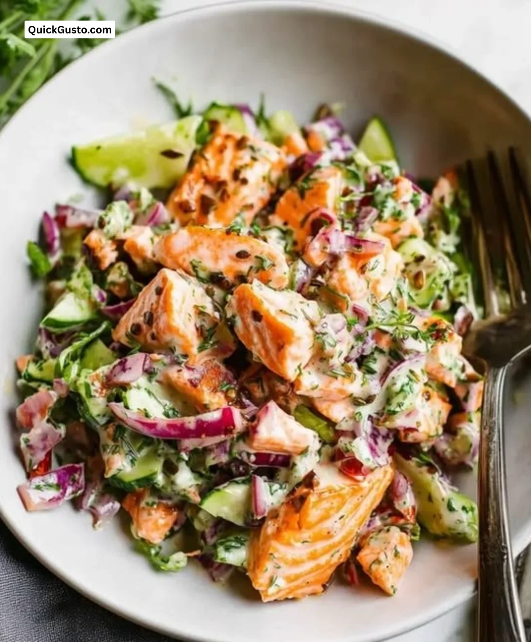 Bowl of flaky and creamy salmon salad with fresh vegetables