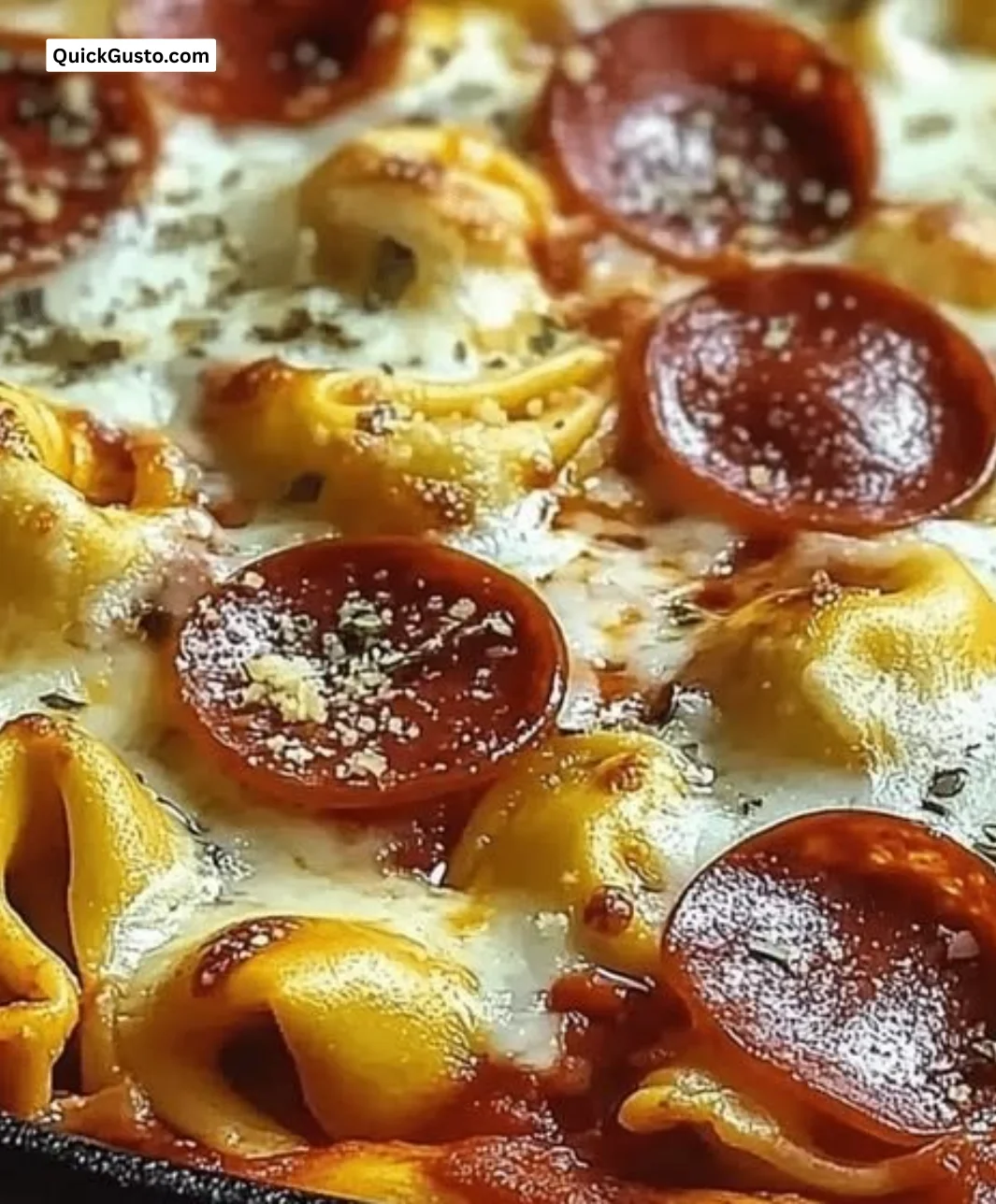 Baked pizza tortellini dish topped with cheese and pepperoni, served fresh.