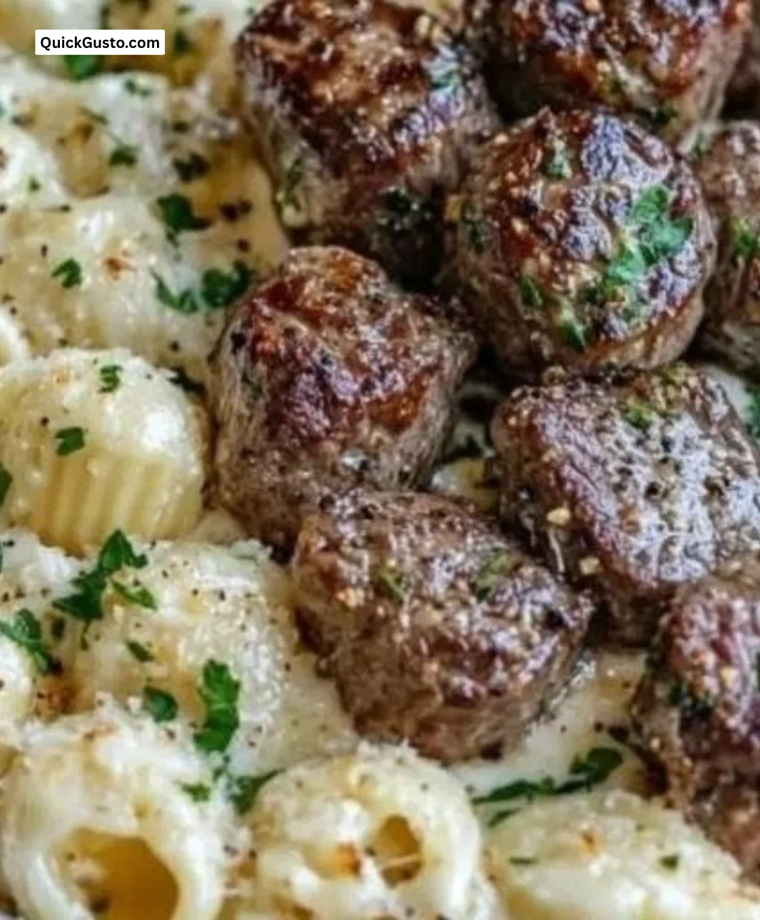 Delicious garlic butter steak bites served over creamy Alfredo pasta shells