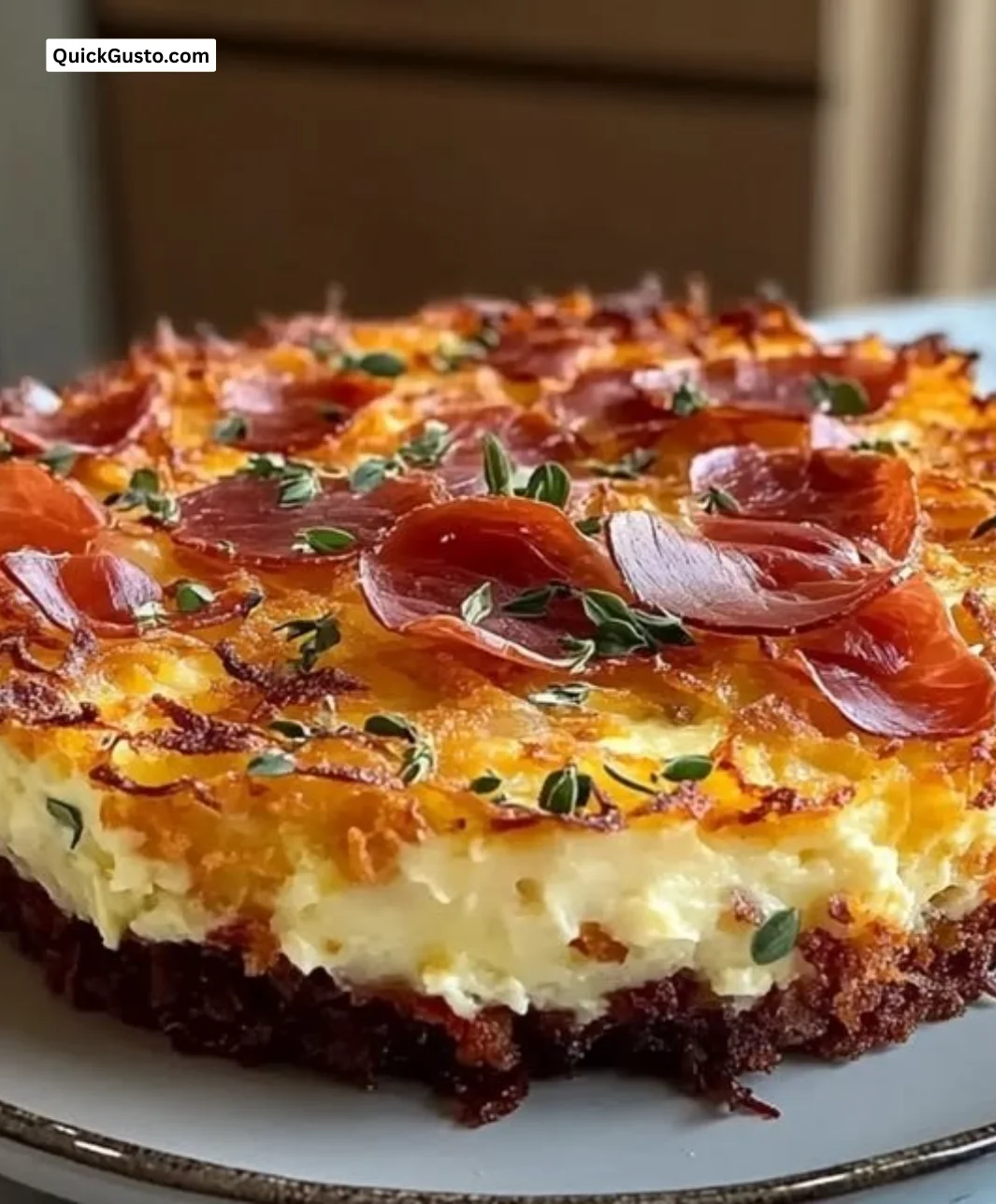 Crispy hash brown crust quiche topped with prosciutto and herbs