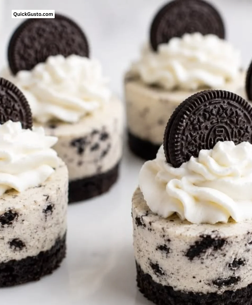 Mini Oreo Cheesecakes topped with crushed Oreos in muffin tins