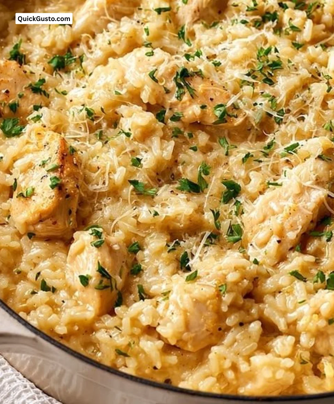 One-pot garlic parmesan chicken and rice in a skillet garnished with parsley