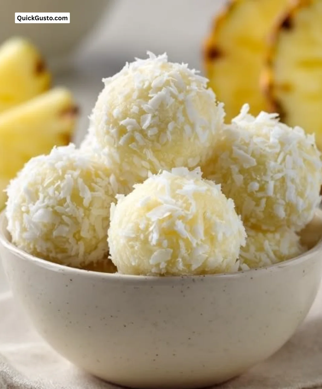 Delicious no-bake pineapple coconut balls on a white plate.