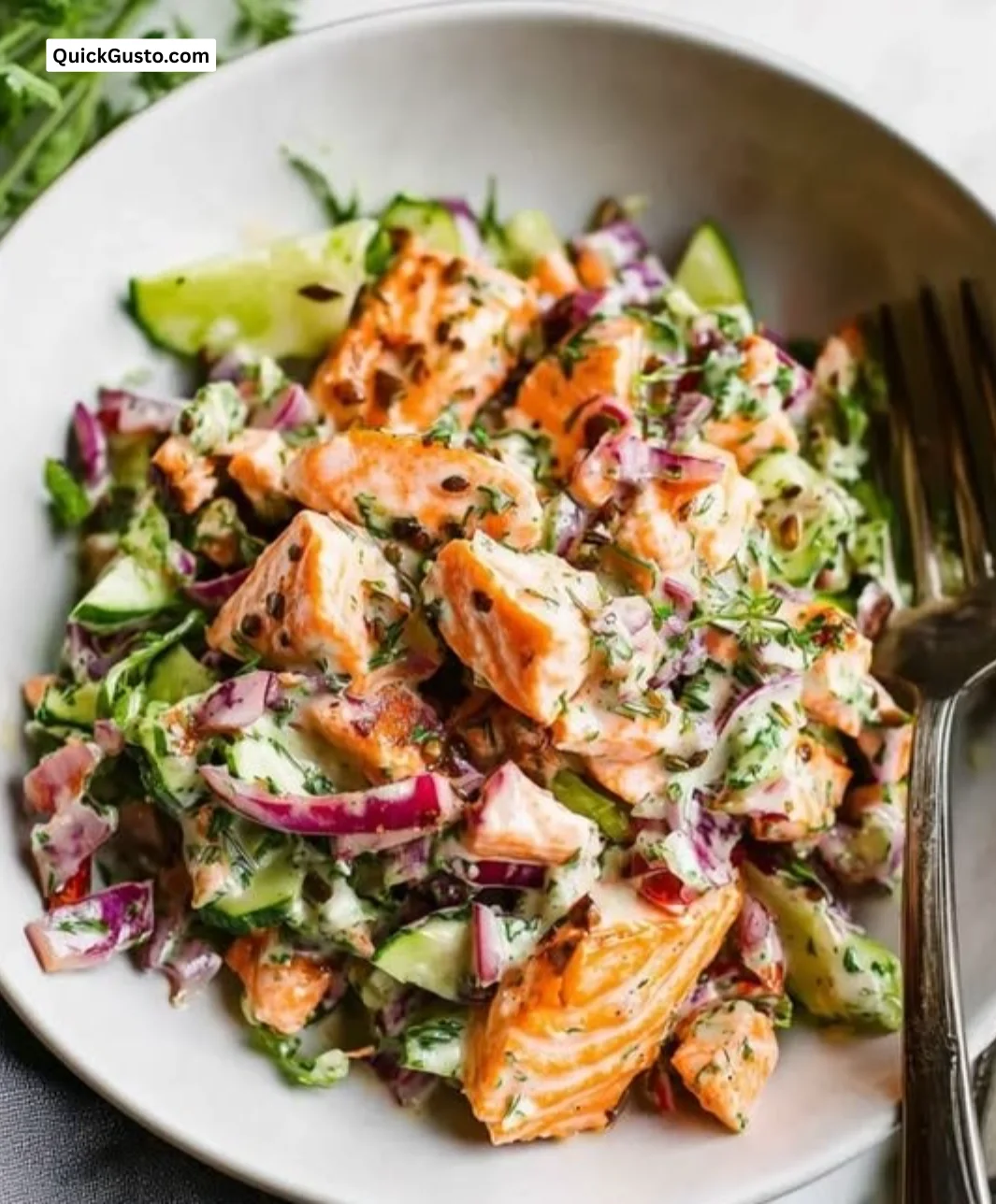 Fresh salmon salad with mixed greens, cherry tomatoes, and avocado.