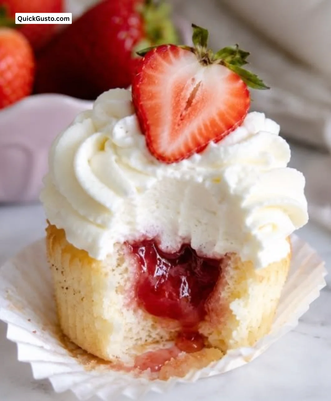 Delicious strawberry shortcake cupcakes topped with fresh strawberries and whipped cream.